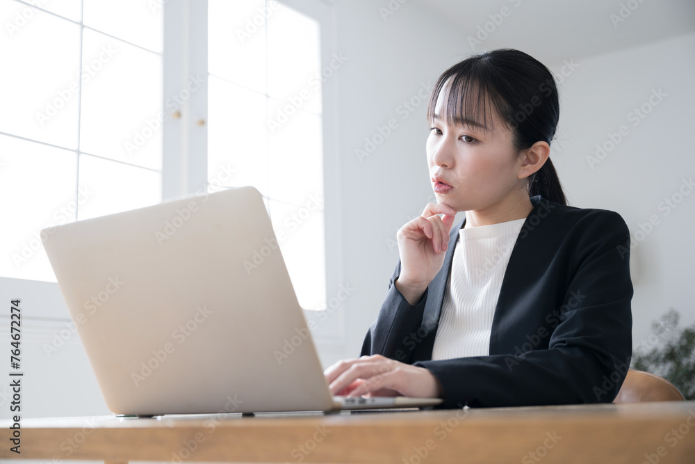 Young businesswoman working on a computer, looking at the screen and worrying. Young businesswoman working on a computer, looking at the screen and worrying.