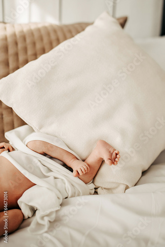 Closeup of a baby s feet on a sofa covered with white sheets