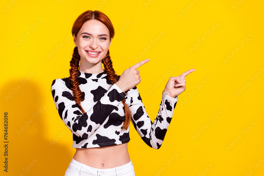 Fototapeta premium Photo of excited cheerful lady dressed cowskin top showing two fingers empty space isolated yellow color background