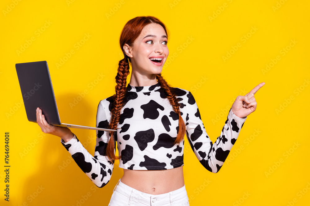 Photo of impressed positive lady dressed cowskin print top working modern device looking pointing empty space isolated yellow color background - obrazy, fototapety, plakaty 