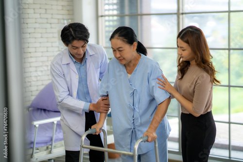 The physical therapist is assisting the patient in practicing walking, providing support for walking. The patient has pain in the ankle and a broken leg.
