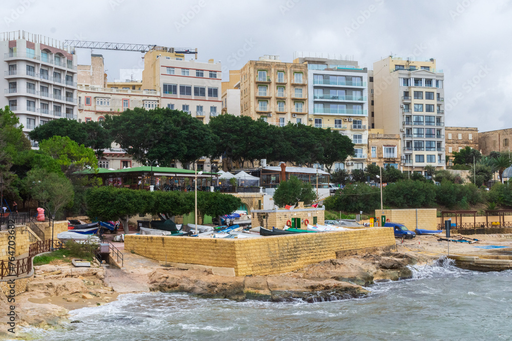 Exiles, Sliema, Malta - October 27th 2021: The small boatyard at Exiles Bay overlooked by hotels and apartments.. Exiles, Sliema, Malta - October 27th 2021: The small boatyard at Exiles Bay overlooked by hotels and apartments..