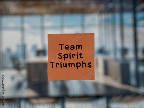 Post note on glass with 'Team Spirit Triumphs'.