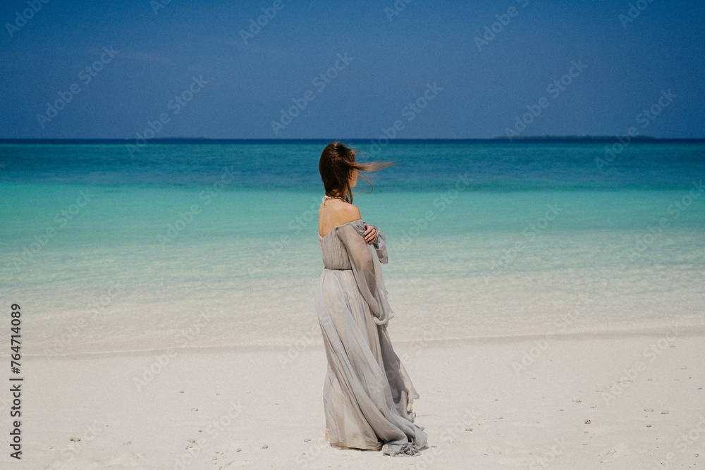 woman walking on the beach in a beautiful dress woman walking on the beach in a beautiful dress