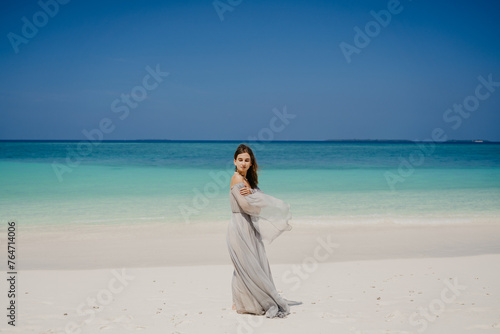 woman walking on the beach in a beautiful dress