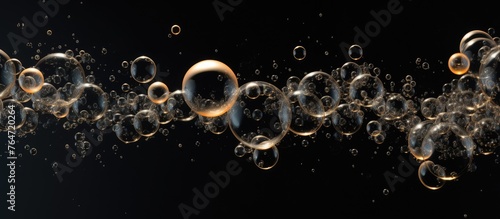 Several translucent bubbles are floating in mid-air against a backdrop of solid black