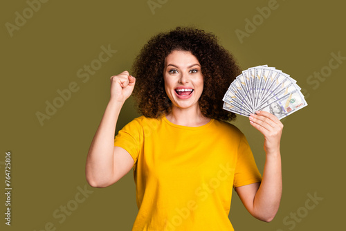 Fotografie Photo of overjoyed woman in yellow t shirt basic clothes raised fist up winning