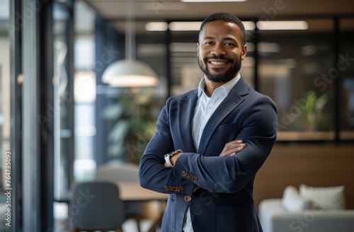 Smiling black businessman in the office. Portrait of a happy business owner or entrepreneur in a suit. Diversity and equality in business concept. © Simon
