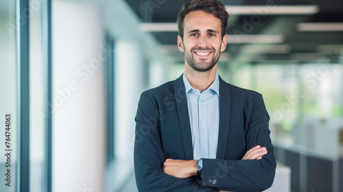 Portrait of handsome confident middle-aged business executive looking at camera smiling with arms crossed at modern office. 