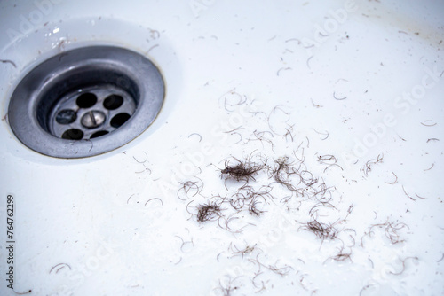 shaved hair from the intimate areas of the pubic area after shaving and depilation remaining on the walls of the bathroom sink, close-up texture