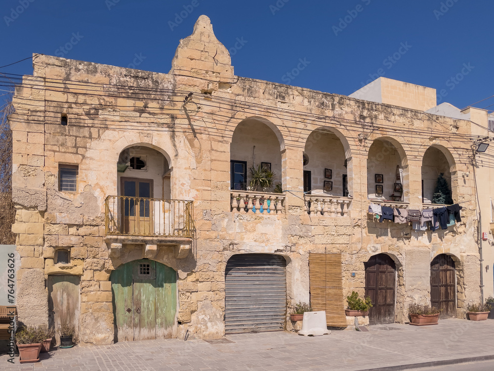 Marsaxlokk, Malta - March 23rd 2022: An old building in the village with laundry drying on the top floor.