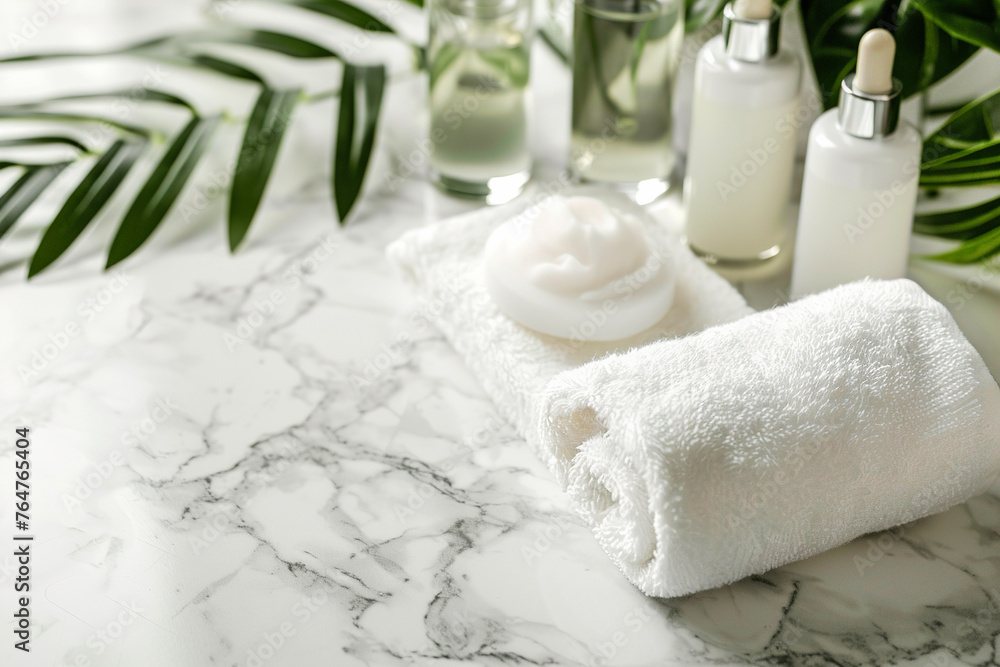Spa treatment accessories, towels and cosmetic bottles on marble table Spa treatment accessories, towels and cosmetic bottles on marble table