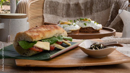 Tomato and Mozzarella sandwich served with kürbis kern oil from Austria. Breakfast table with high nutritions vegan and vegetable food (ID: 764768249)