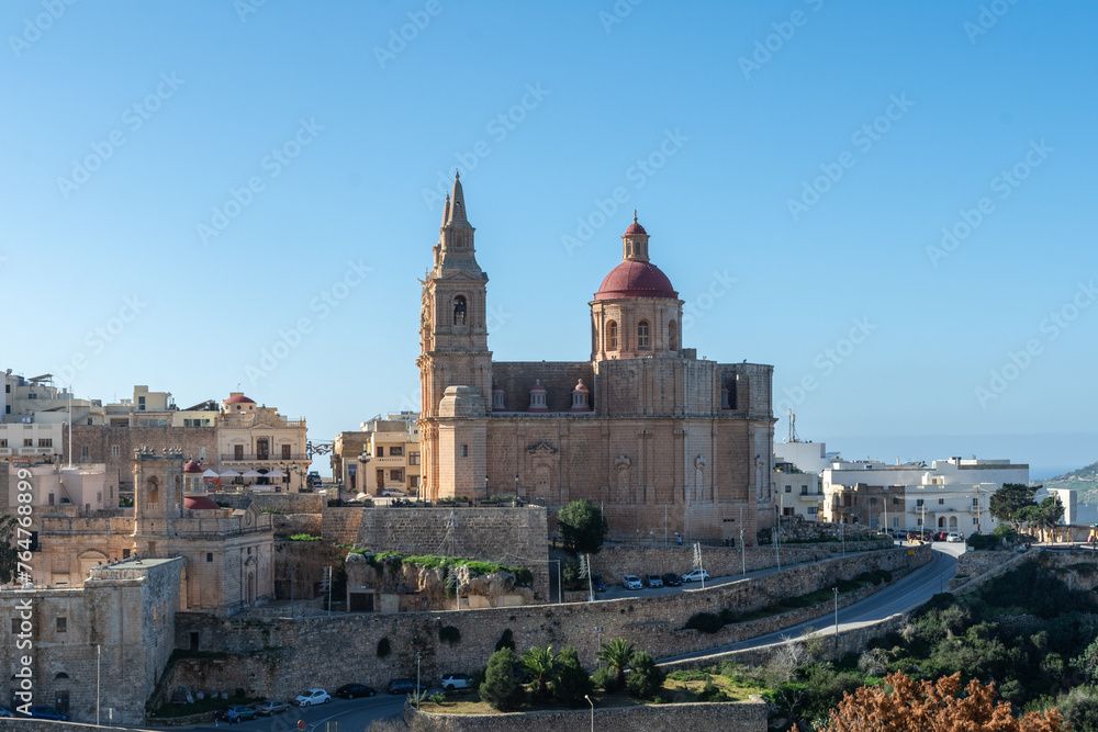 Mellieha, Malta - December 25th 2022: The 19th century Parish Church of the Nativity of the Virgin Mary alongside the 16th century church the Sanctuary of Our Lady of Mellieħa.
