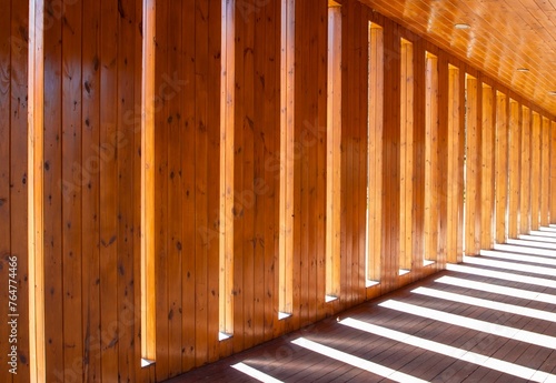 a wall of wood paneling through which sunlight shines