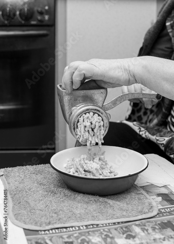 Old woman disassemble a meat grinder	 photo