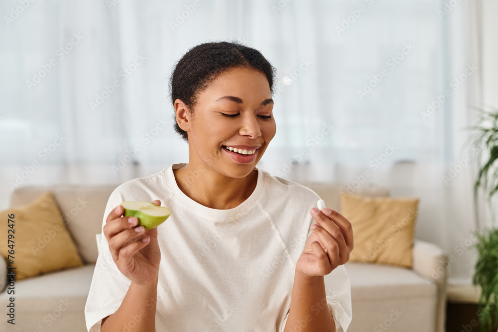 happy african american nutritionist compares supplements with fresh apple for a healthy diet happy african american nutritionist compares supplements with fresh apple for a healthy diet