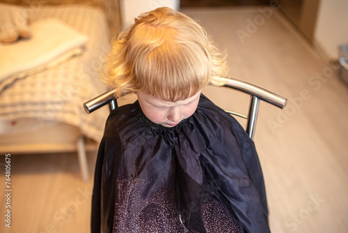 happy little girl shows off her trendy new haircut at the beauty salon.