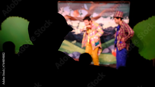 silhouette of child audience watching theater play
