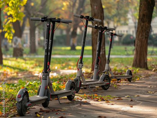 Electric scooters for rent standing in the park.  photo