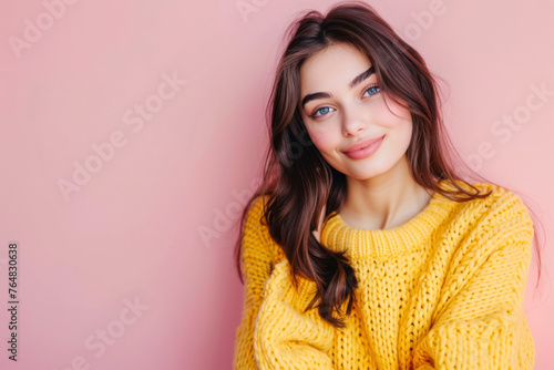 Smiling young brunette woman girl in yellow sweater posing isolated on pastel pink wall background studio portait. © Hunman