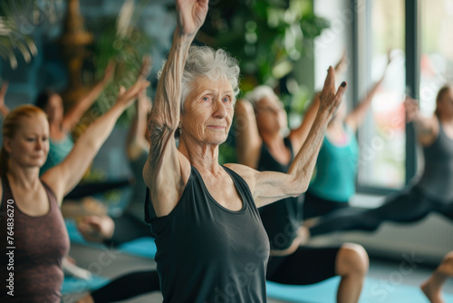 An elderly woman practicing pilates with a group in a fitness studio  highlighting the importance of physical activity at all ages
