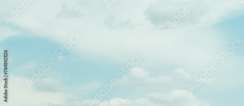 Blue sky with clouds and white background with green tint