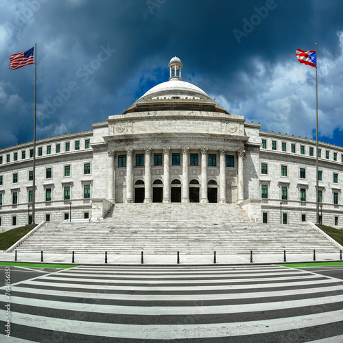Puerto Rico Capitol Building in San Juan with American and Purto Rico flags waving in the wind on a cloudy day photo