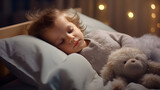 Cute little girl sleeping sweetly with a toy in her bed covered with a soft blanket on a bokeh background. The concept of healthy sleep, feeling safe and calm