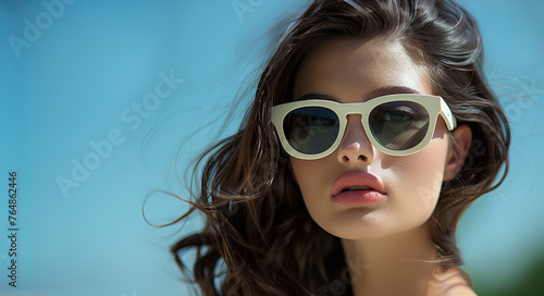 Beautiful model girl in cool sunglasses with eco friendly style put it on a brunette mode. Gorgeous girl in white glasses. The concept of youth and beauty.