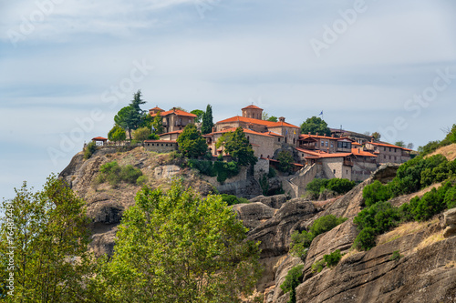 Monastery Meteora Greece. Stunning summer panoramic landscape. View at mountains and green forest against epic blue sky with clouds. UNESCO heritage list object.