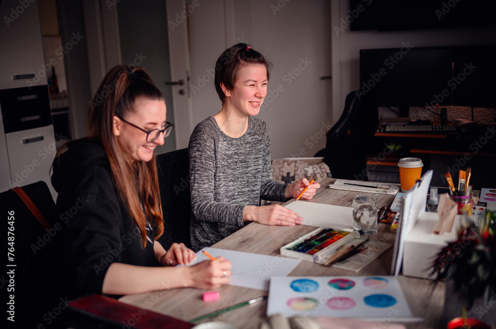 Fototapeta premium A heartwarming scene of two friends laughing and enjoying their artistic hobbies together at a cluttered and lively workspace
