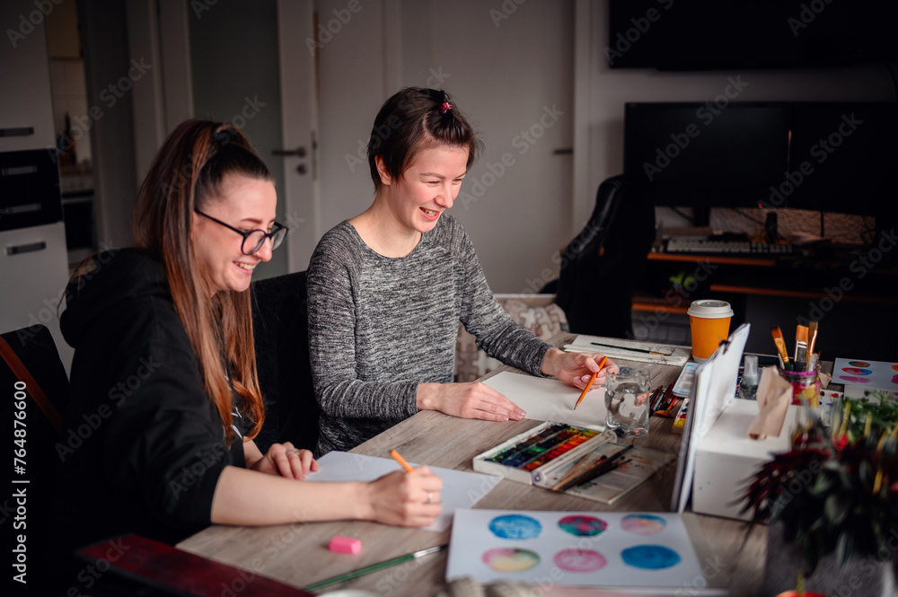 Fototapeta premium A heartwarming scene of two friends laughing and enjoying their artistic hobbies together at a cluttered and lively workspace