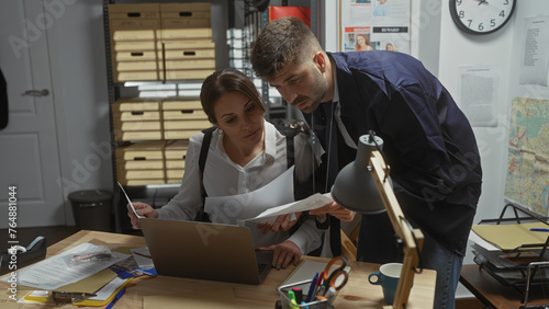 A focused man and woman examine documents together at a cluttered detective office, symbolizing teamwork in investigation.