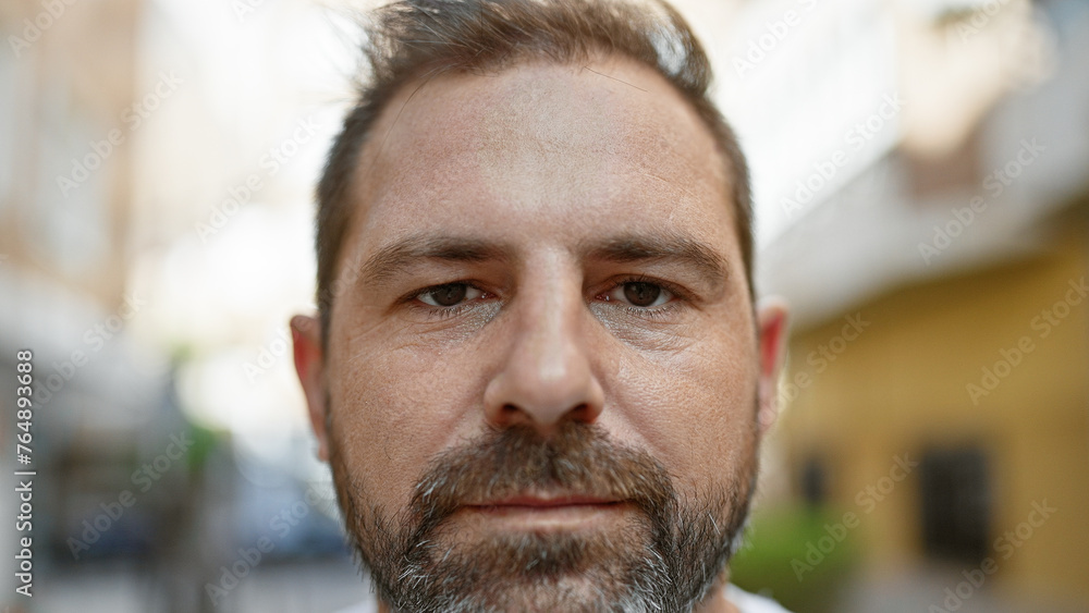Close-up portrait of a mature hispanic man with grey hair, standing on an urban street. Close-up portrait of a mature hispanic man with grey hair, standing on an urban street.