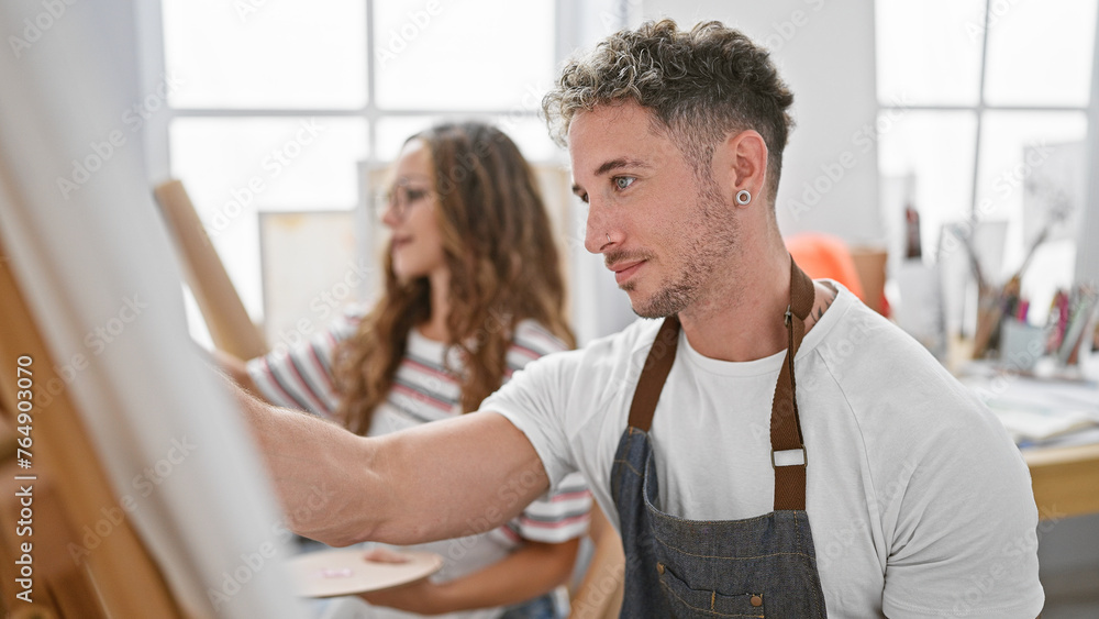 A man and a woman focused on painting in a bright, artistic studio, embodying creativity and collaboration. A man and a woman focused on painting in a bright, artistic studio, embodying creativity and collaboration.