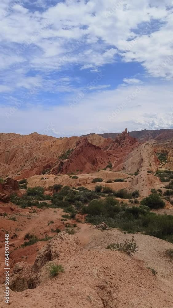 Fairytale canyon Skazka in Kyrgyzstan. Sharp Mountain is a rock made of red orange stone and clay against a bright blue sky without clouds and desert vegetation in Fairy Tale Canyon Kyrgyzstan, Skazka Fairytale canyon Skazka in Kyrgyzstan. Sharp Mountain is a rock made of red orange stone and clay against a bright blue sky without clouds and desert vegetation in Fairy Tale Canyon Kyrgyzstan, Skazka