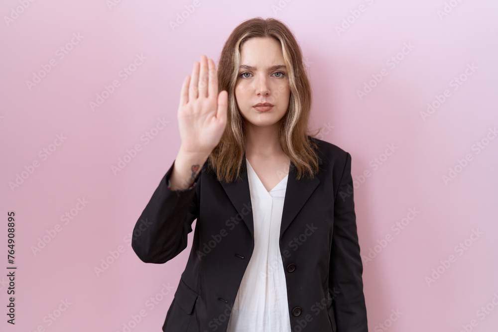 Young caucasian business woman wearing black jacket doing stop sing with palm of the hand. warning expression with negative and serious gesture on the face. Young caucasian business woman wearing black jacket doing stop sing with palm of the hand. warning expression with negative and serious gesture on the face.