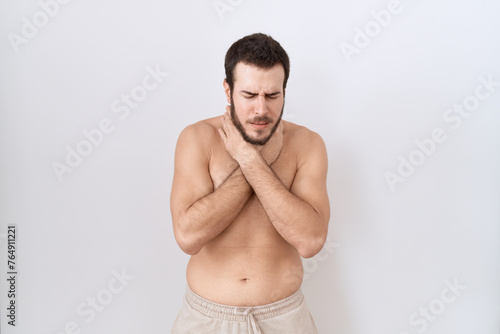 Young hispanic man standing shirtless over white background shouting and suffocate because painful strangle. health problem. asphyxiate and suicide concept.