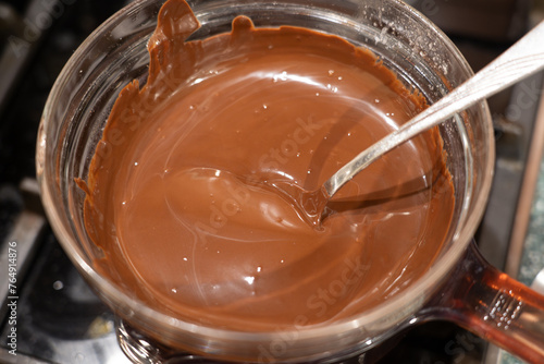 Melt chocolate in glass bowl over a pot of boiling water on gas stove. Cooking Salted Caramel Chocolate Cold Cake Series.