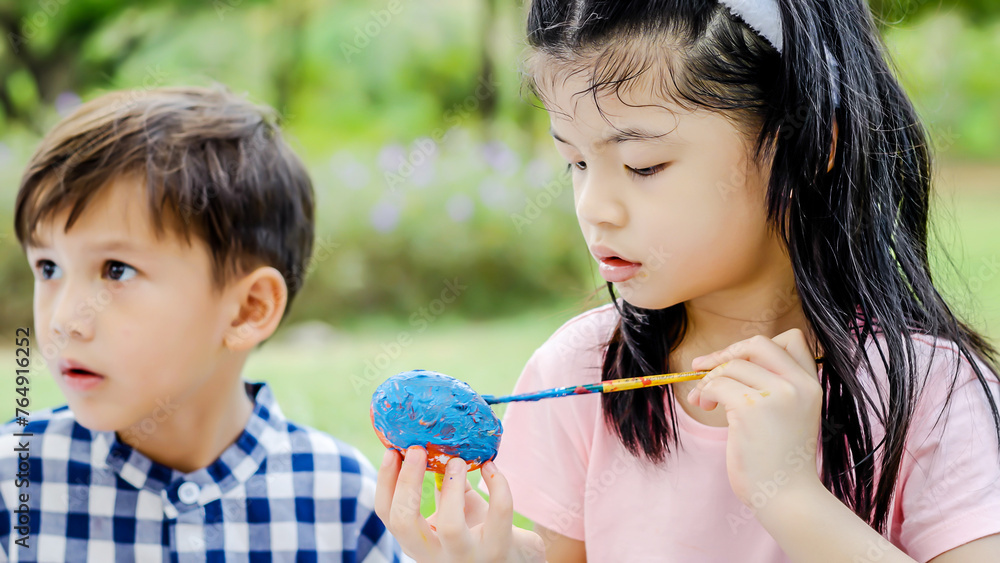 Happy group children in park, cute asian girl and boy with mix race friend, paint egg with blowing soap bubbles together on green grass in garden. Kids celebrate Easter holiday outdoor Happy group children in park, cute asian girl and boy with mix race friend, paint egg with blowing soap bubbles together on green grass in garden. Kids celebrate Easter holiday outdoor