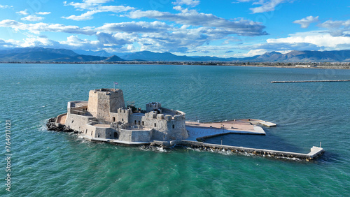 Aerial drone photo of castle of Bourtzi built at sea a popular attraction in city of Nafplio former capital of Greece as seen in the morning with nice white clouds and deep blue sky, Argolida, Greece