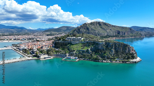 Aerial drone photo of iconic Acronafplia fortress overlooking old city of Nafplio below famous castle of Palamidi as seen in a spring morning with beautiful clouds and deep blue sky, Argolida, Greece