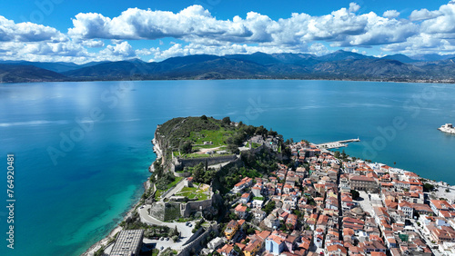 Aerial drone photo of iconic Acronafplia fortress overlooking old city of Nafplio below famous castle of Palamidi as seen in a spring morning with beautiful clouds and deep blue sky, Argolida, Greece