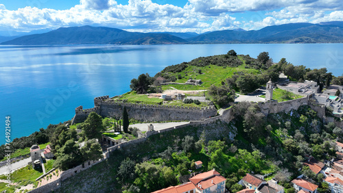 Aerial drone photo of iconic Acronafplia fortress overlooking old city of Nafplio below famous castle of Palamidi as seen in a spring morning with beautiful clouds and deep blue sky, Argolida, Greece © aerial-drone