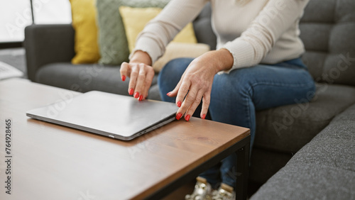 Фотография Caucasian woman closing laptop in cozy living room signaling end of remote workd
