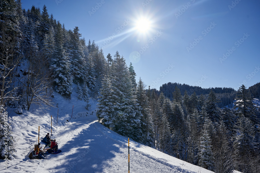 Sattel, Swiss Alps. A captivating image showcases a group of people riding a snowmobile in a snowy mountain.