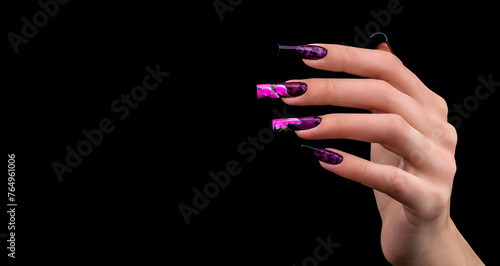 Hand with a beautiful manicure on a black background. Nail design. Extended nails.