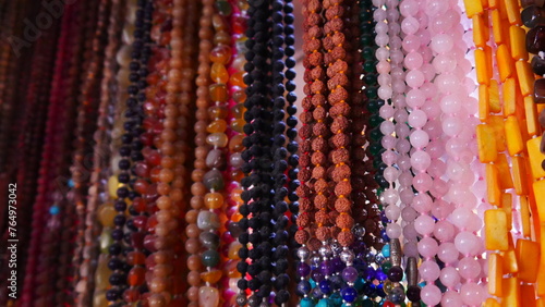 Gros colliers style artistique de l'inde, vente dans un stand, bijoux de religion et de croyance, objet de valeur, de toutes les couleurs, produit insoutenables touristique, représentation hindouisme photo