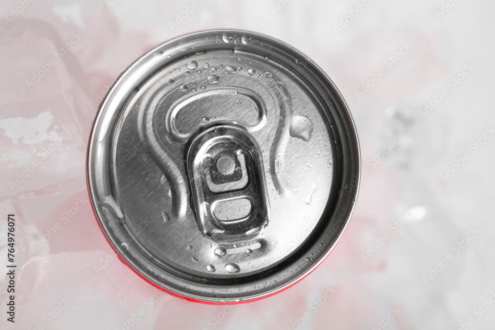 Obraz premium Energy drink in wet can and ice cubes on light background, top view
